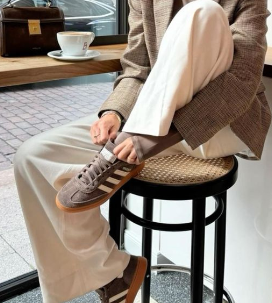 mulher sentada em um café com um look estiloso